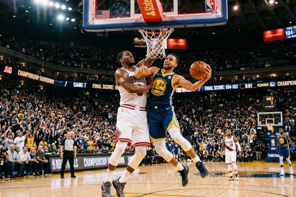 A Golden State Warriors player drives to the basket against a Chicago Bulls defender in a packed arena during a close game