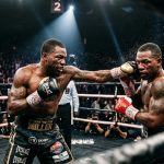 Anthony Miller lands a punch to his opponent's head during a boxing match as sweat sprays from the impact