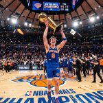 New York Knicks player #8 holds the championship trophy at Madison Square Garden as confetti falls after a title win